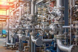 Industrial pipeline system featuring metallic valves and piping in a processing facility, showcasing complex machinery and infrastructure essential for fluid control and management.